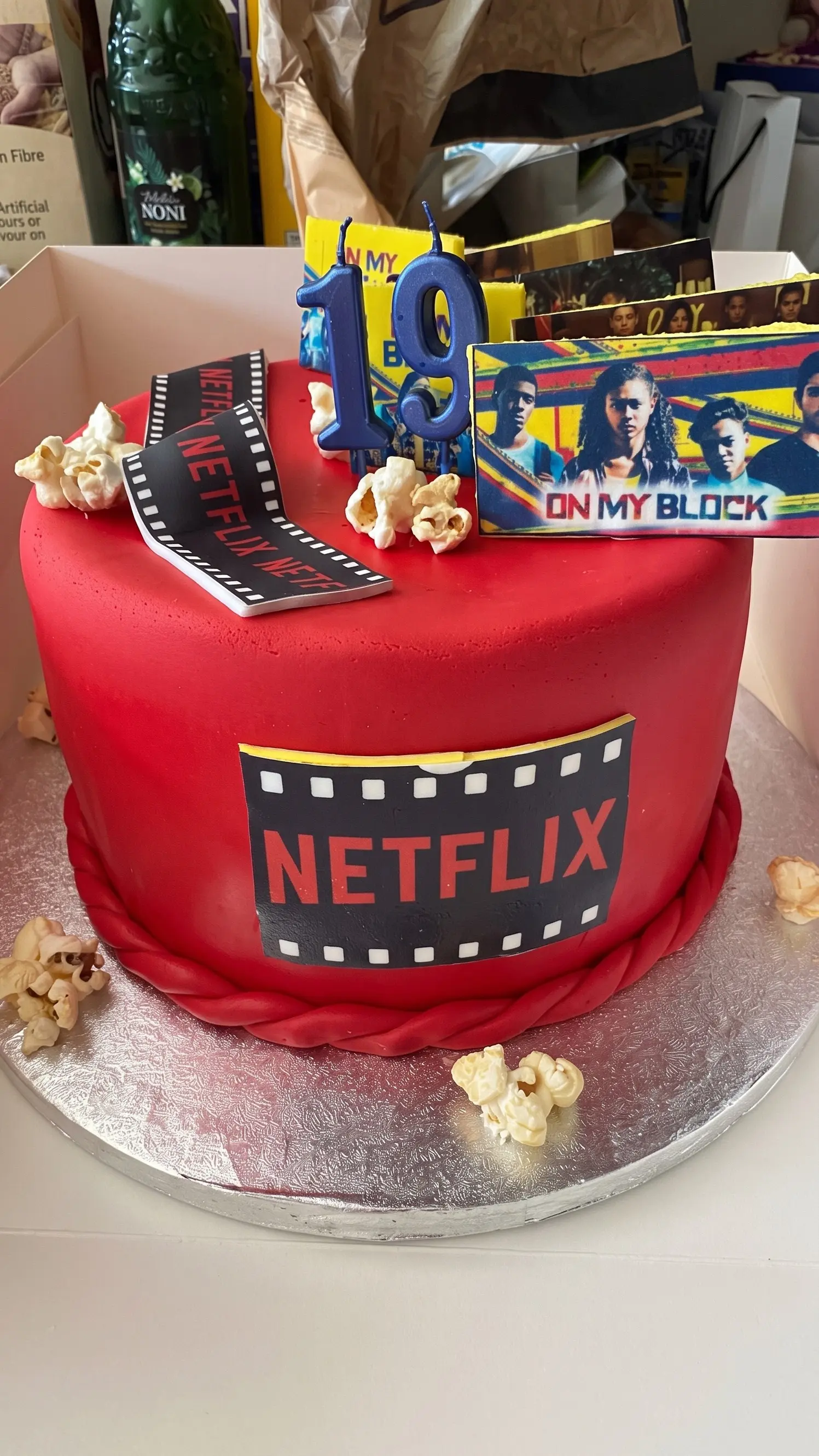 Red birthday cake decorated with film strip details, popcorn and number nineteen candles